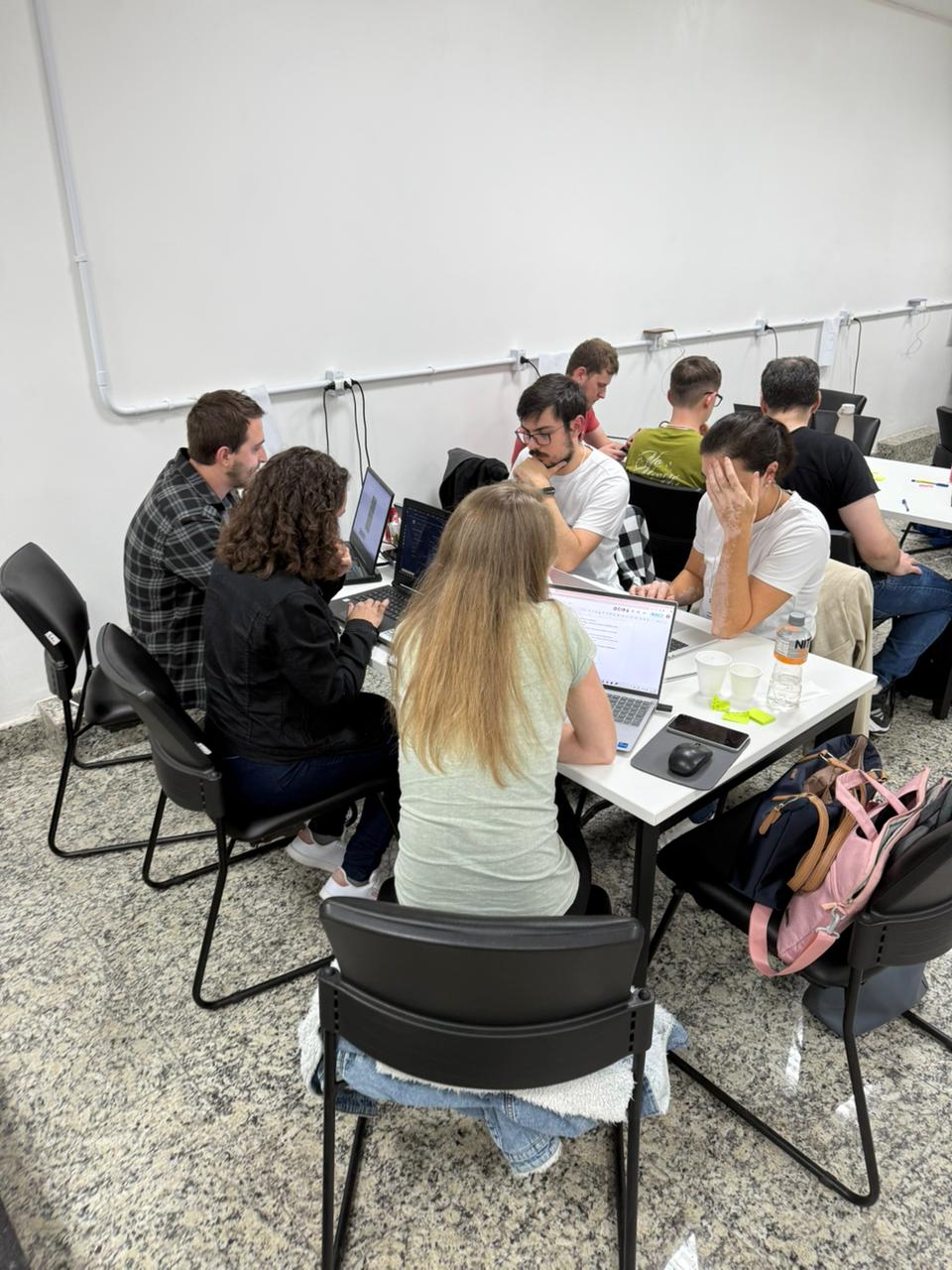 Grupo trabalhando ao redor das mesas